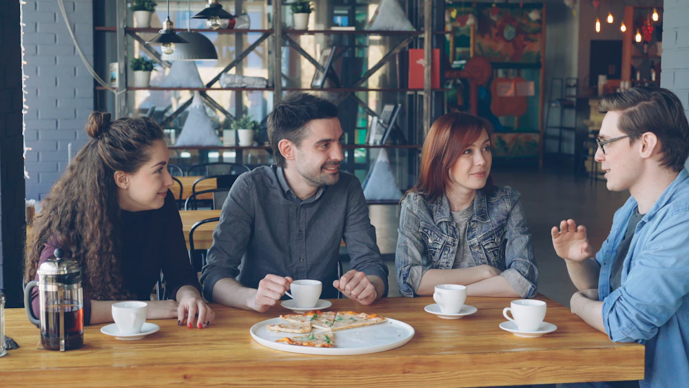 Friends talking around a cafe table
